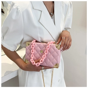 Pink box crossbody bag with quilted pattern, acrylic chain, and gold metal hardware detail
