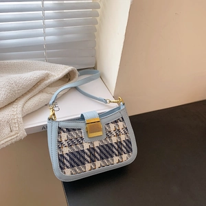 Chic light blue houndstooth shoulder bag with gold metal clasp and leather strap