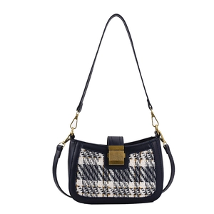 Navy blue leather shoulder bag with tweed panel and vintage gold clasp on white background