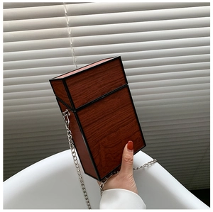 Detailed view of women's wood grain crossbody bag with silver chain strap and rigid shell