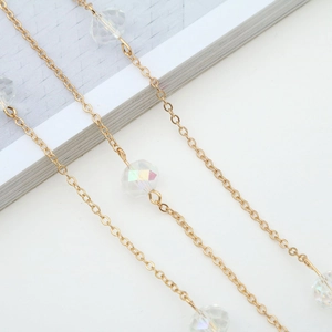Chaîne à lunettes dorée élégante avec des perles en cristal AB 10mm sur un fond blanc pur