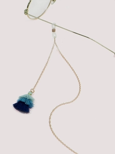 Detail of gold eyewear chain featuring triple-layered blue gradient tassels and silicone grips