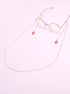 Détail d'une chaîne de lunettes dorée avec de mignons pendentifs en forme de fraise