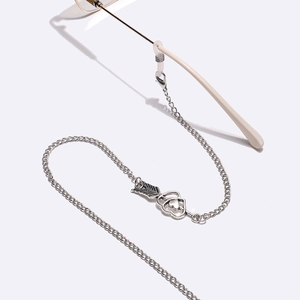 Detail of silver glasses chain featuring a heart-and-arrow pendant and silicone loops