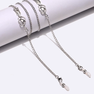 Silver alloy eyeglass chain with heart and arrow charms on white display stand
