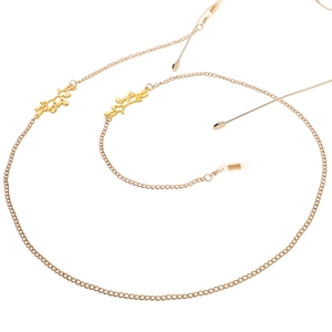 Golden metal eyewear chain with delicate leaf pendants and non-slip rubber loop ends