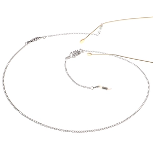 Elegant silver fish bone eyewear chain with silicone loops on minimalist gold glasses