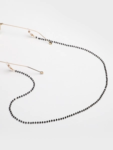 Detail of black beaded glasses chain with gold connectors and clear rubber loops