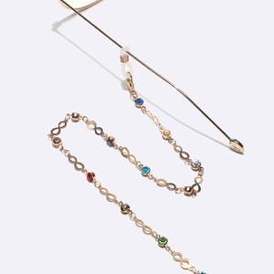 Gold non-slip eyewear chain with infinity links and colorful rhinestones on white background