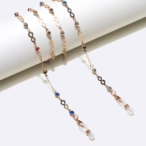 Golden eyewear chain with colorful rhinestones and infinity symbols on white stand