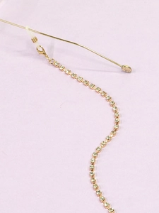 Close-up of golden eyewear chain with square-cut rhinestones and anti-slip rubber loops