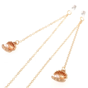 Golden metal eyewear chain with elegant shell pendants and white pearls on white background