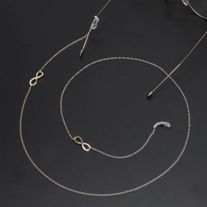 Golden infinity symbol eyewear chain with non-slip silicone loops on dark background