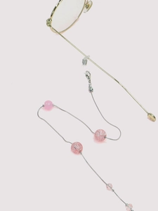 Macro shot of pink beaded eyeglass chain with silver metal links and silicone loops