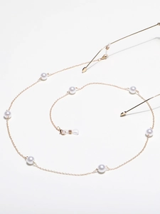 Elegant golden metal eyewear chain with white faux pearls on a clean white background