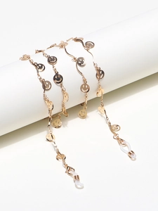 Elegante goldene Brillenette mit polierten Smiley-Anhängern auf weißem Ständer präsentiert