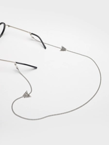 Detailed macro view of silver butterfly charms on a polished metal eyewear chain strap