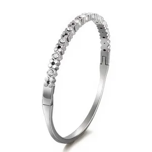 Detailed close-up of a silver-tone rigid bracelet with sparkling pave-set zircons on white base