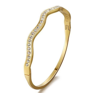 Detailed macro view of gold-plated wavy bangle with inlaid crystals and side buckle