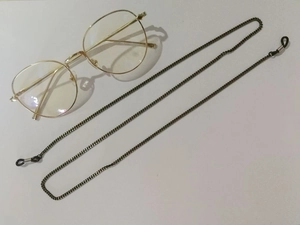 Macro detail of bronze metal glasses chain with black anti-slip silicone connectors
