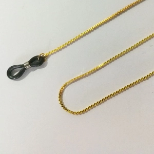 Detail of golden metal eyewear chain with spiral structure and black anti-slip rubber loops