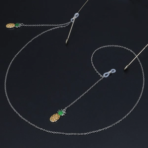 Detail of silver glasses chain with vibrant yellow and green enamel pineapple pendants