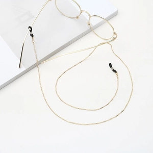 Elegante catenella per occhiali in metallo dorato con anelli in gomma nera su sfondo bianco