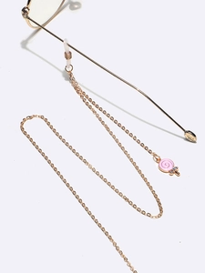 Detail of golden glasses chain with pink candy pendant and white silicone connector