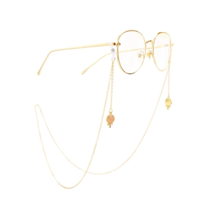 Golden non-slip metal eyewear chain with rhinestone candy and shell pendants on glasses