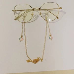 Detail of gold glasses chain featuring colorful enamel umbrella charms and silicone loops