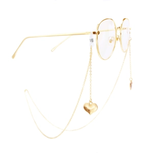 Golden metal eyewear frames with decorative heart pendant chain in a stylish minimalist design