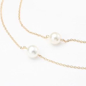 70cm gold eyewear chain with polished imitation pearls on a clean white background