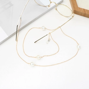 Elegant 70cm gold eyewear chain with white pearls on minimalist background with glasses