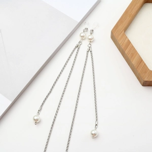 Detail einer silbernen Brillenlkette mit weißen Perlen und Silikonschlaufen auf weißem Grund