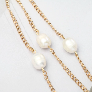 Chaîne de lunettes dorée élégante avec trois perles d'eau douce baroques sur fond blanc