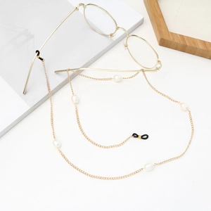 Chaîne de lunettes dorée avec perles d'eau douce blanches sur fond blanc minimaliste