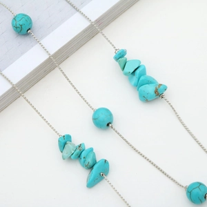 Chaîne de lunettes tendance avec perles turquoise et chaîne argentée sur fond blanc