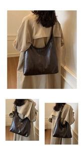 Detail of dark brown leather tote bag showing soft crescent shape and stitched seam