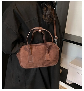 Detailed view of dark brown matte suede Boston bag with fine double stitching and metal hooks