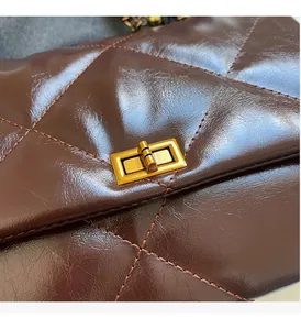 Close-up of vintage gold twist lock and quilted oil wax leather on underarm bag