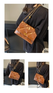 Detailed view of the brown quilted leather bag with a gold metal chain and spherical charm