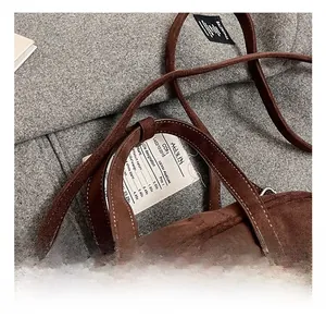 Detail of a brown matte suede tote bag with distinctive white contrast stitching accents