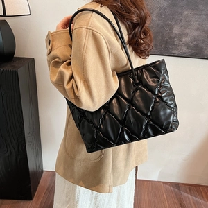 Chic black quilted tote bag with padded rhombus pattern and slim shoulder straps