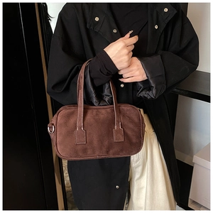 Detail of dark brown suede boston bag with silver metal D-rings for crossbody strap