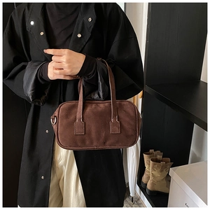 Detailed view of dark brown matte suede Boston bag featuring fine stitching and silver D-rings