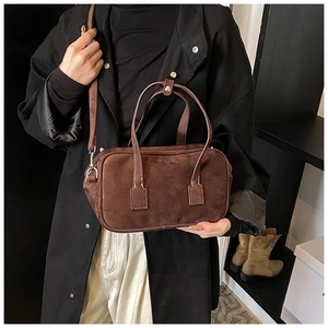 Macro view of dark brown frosted Boston bag with fine stitching and metal buckle detail