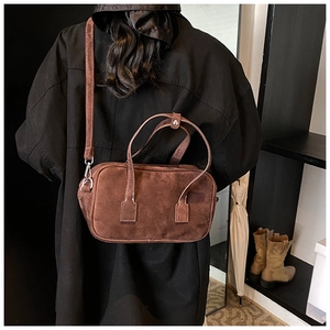 Detail view of retro brown frosted texture Boston bag worn over shoulder in vintage setting