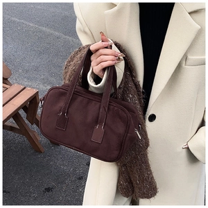 Detail of vintage matte dark brown suede Boston bag with double handles and neat stitching