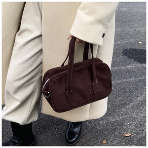 Detail of dark brown suede Boston bag featuring contrast stitching and silver hardware