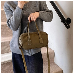 Olive green frosted Boston bag with dual handles and long strap on a female model